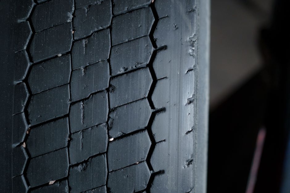 Technician checking tire tread depth and alignment
